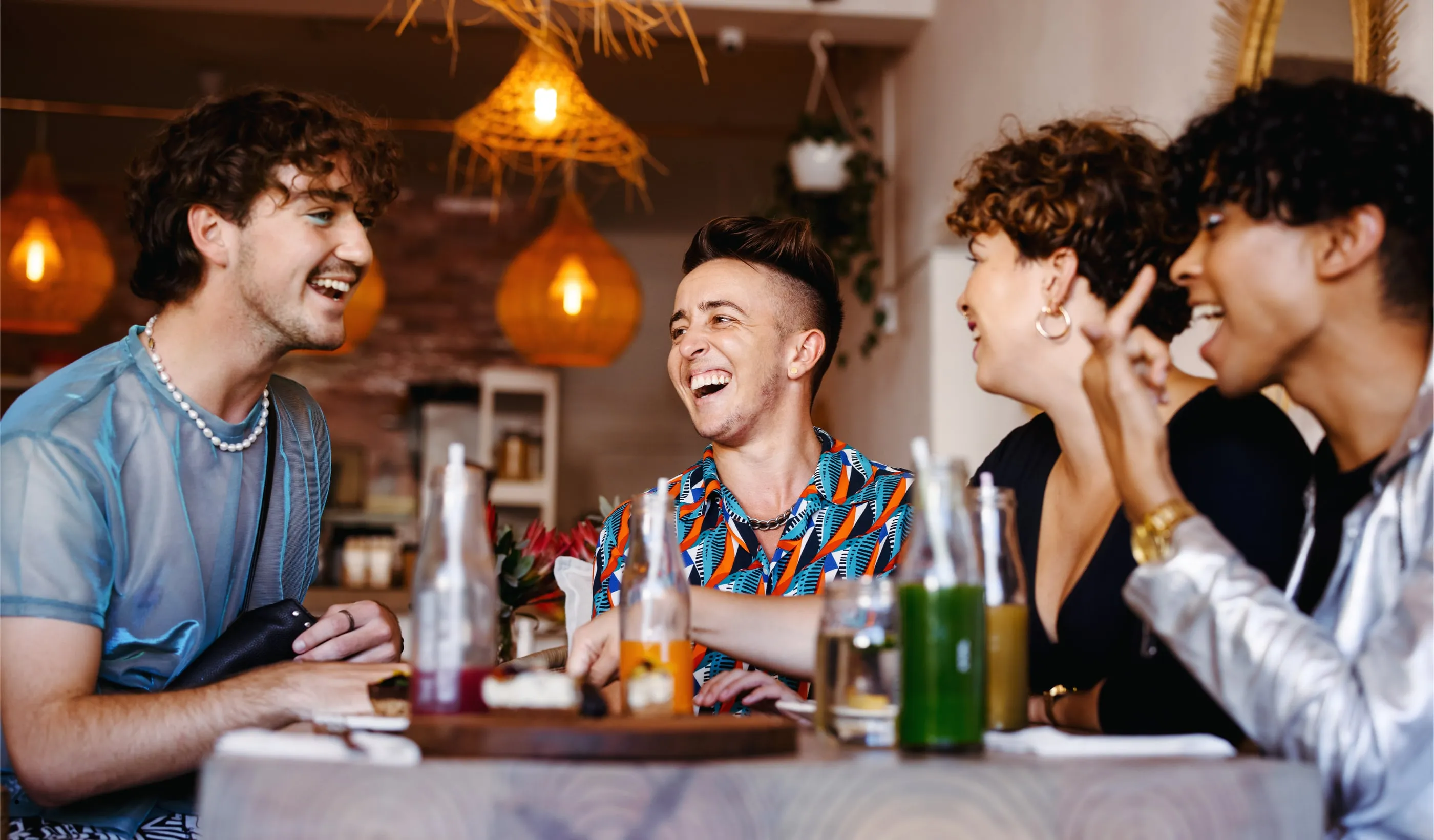 Des convives éclatent de rire autour d’une table