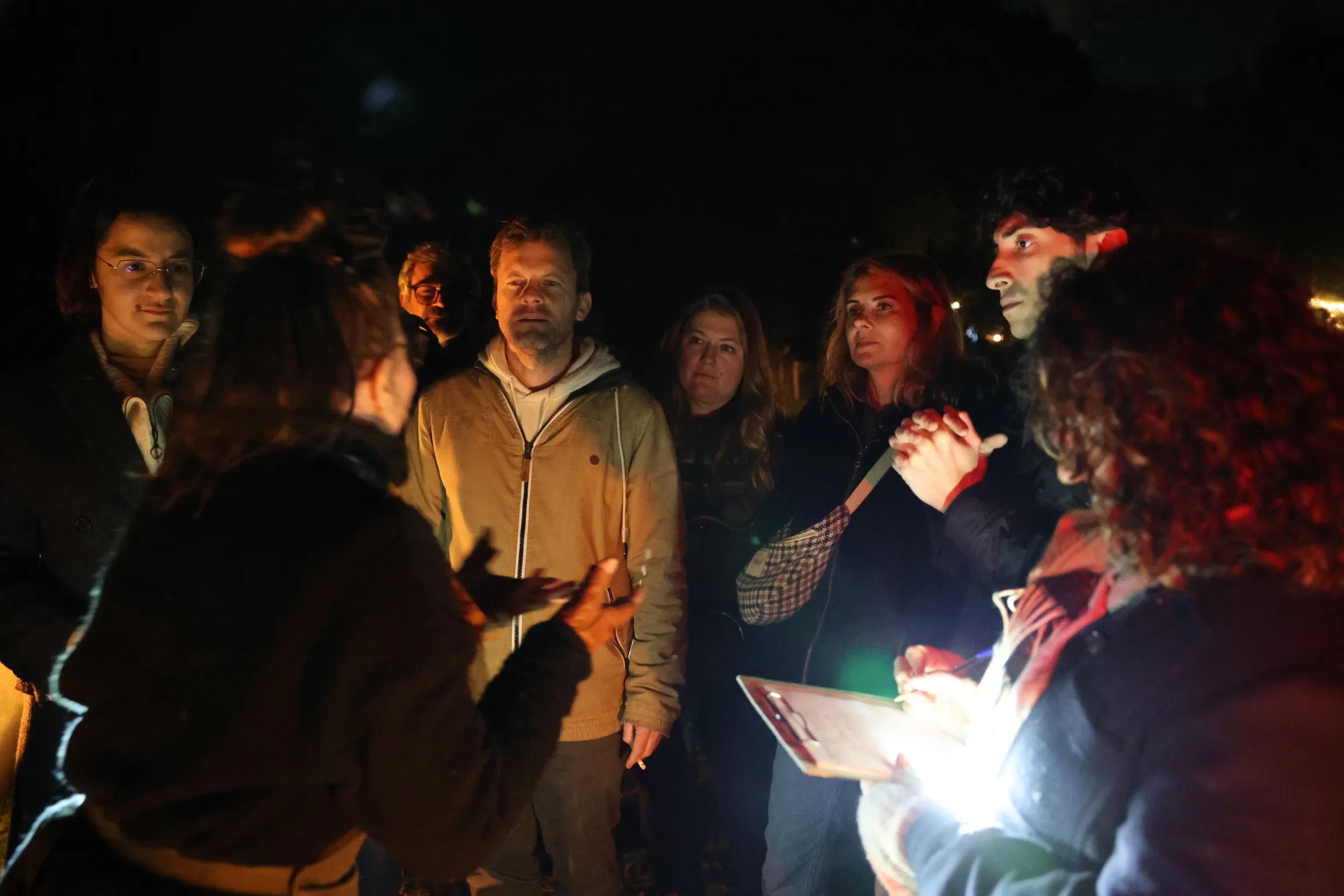 Les enquêteurs interrogent un témoin à la lampe torche, de nuit
