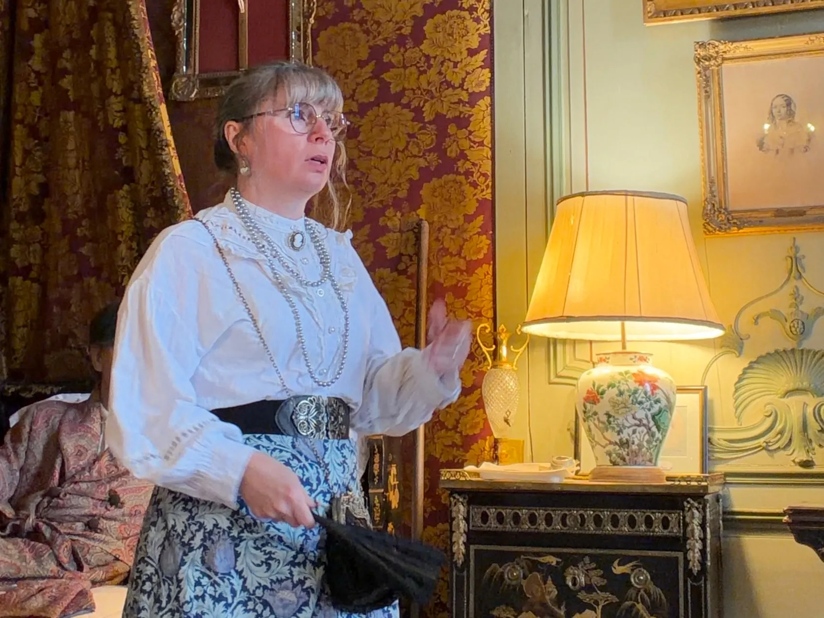 Dorothée en costume d’époque guide la visite dans une chambre de château